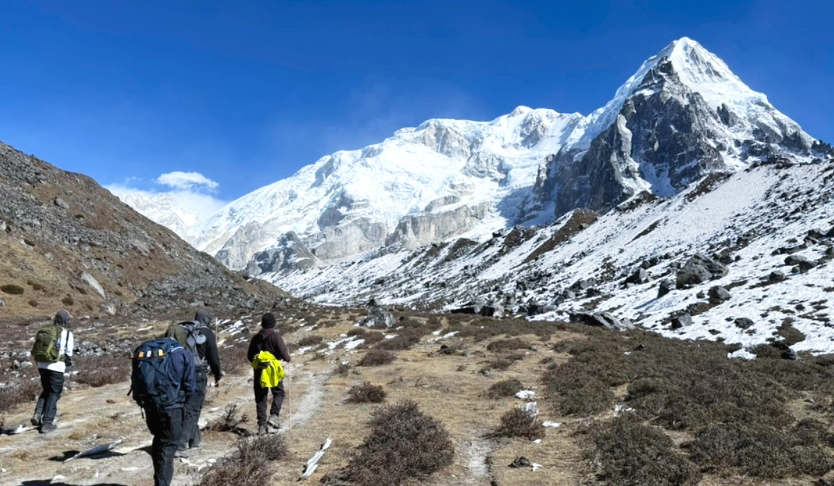 Group of adventure trekkers hiking towards Kanchenjunga Base Camp during Kanchenjunga circuit trek in Nepal. 