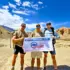 Upper Mustang Trek group with Explore Vision Nepal banner surrounded by Himalayan landscapes