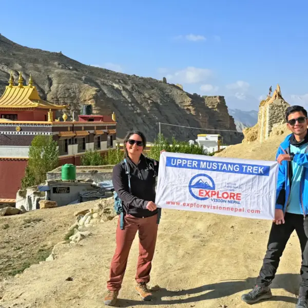 Trekkers with Explore Vision Nepal banner at a monastery during the Upper Mustang Trek in Mustang Nepal