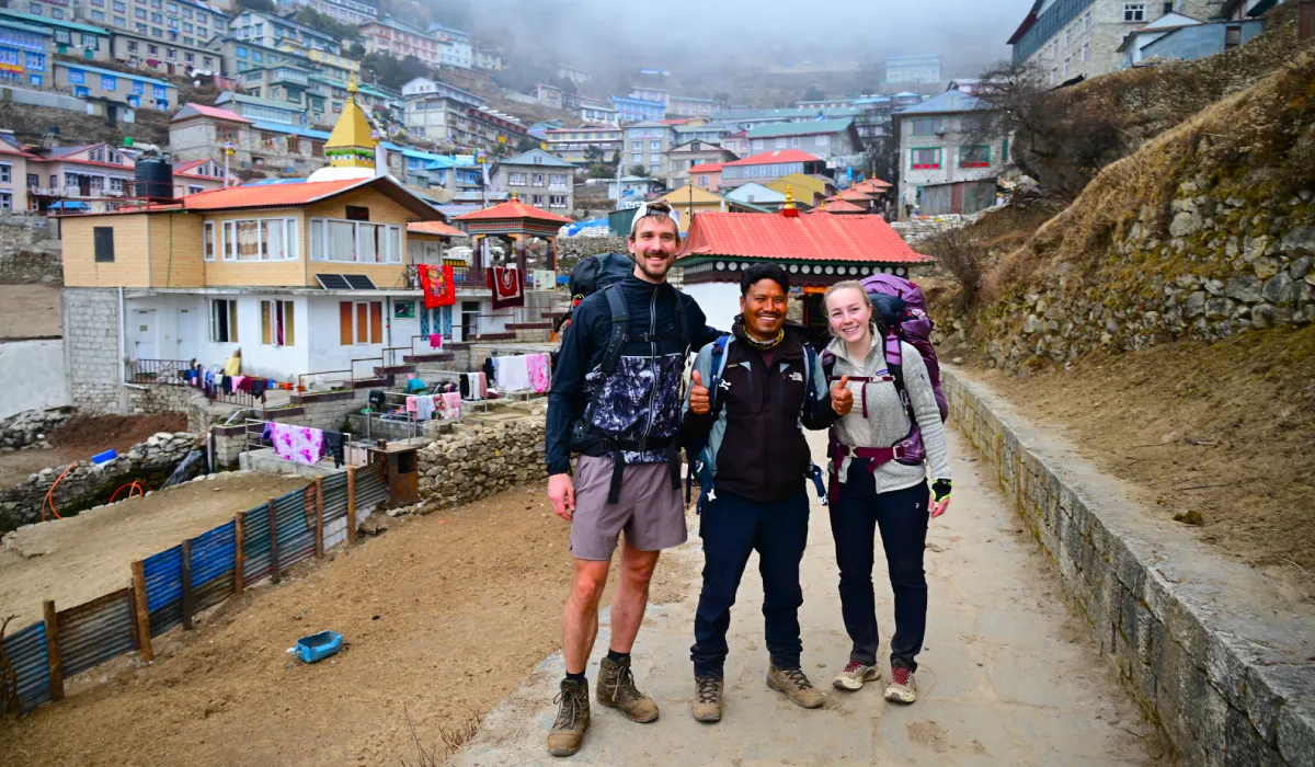 Trekkers at the Namche Bazaar entrance during the Everest Base Camp Trek with happy face as it was one of the hard day of Everest Base Camp trek difficulty as they have to climb up Namche hill to reach Namche Bazaar, Nepal.