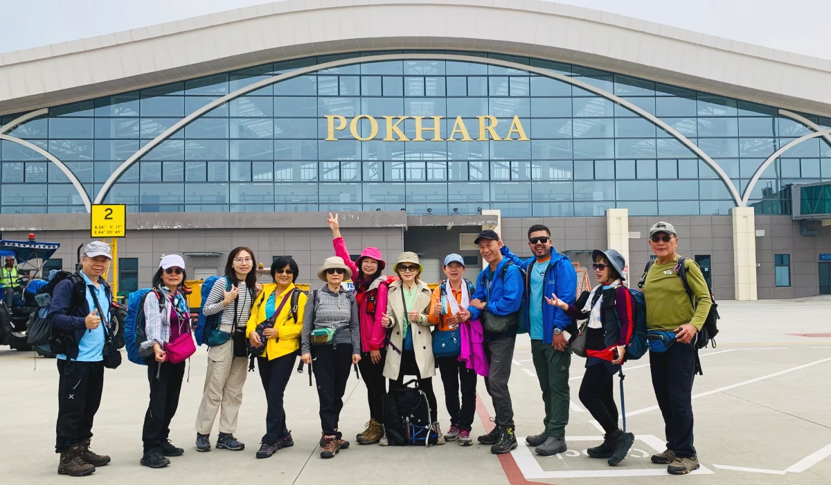 Travelers at Pokhara Airport with a Pokhara sign in Nepal