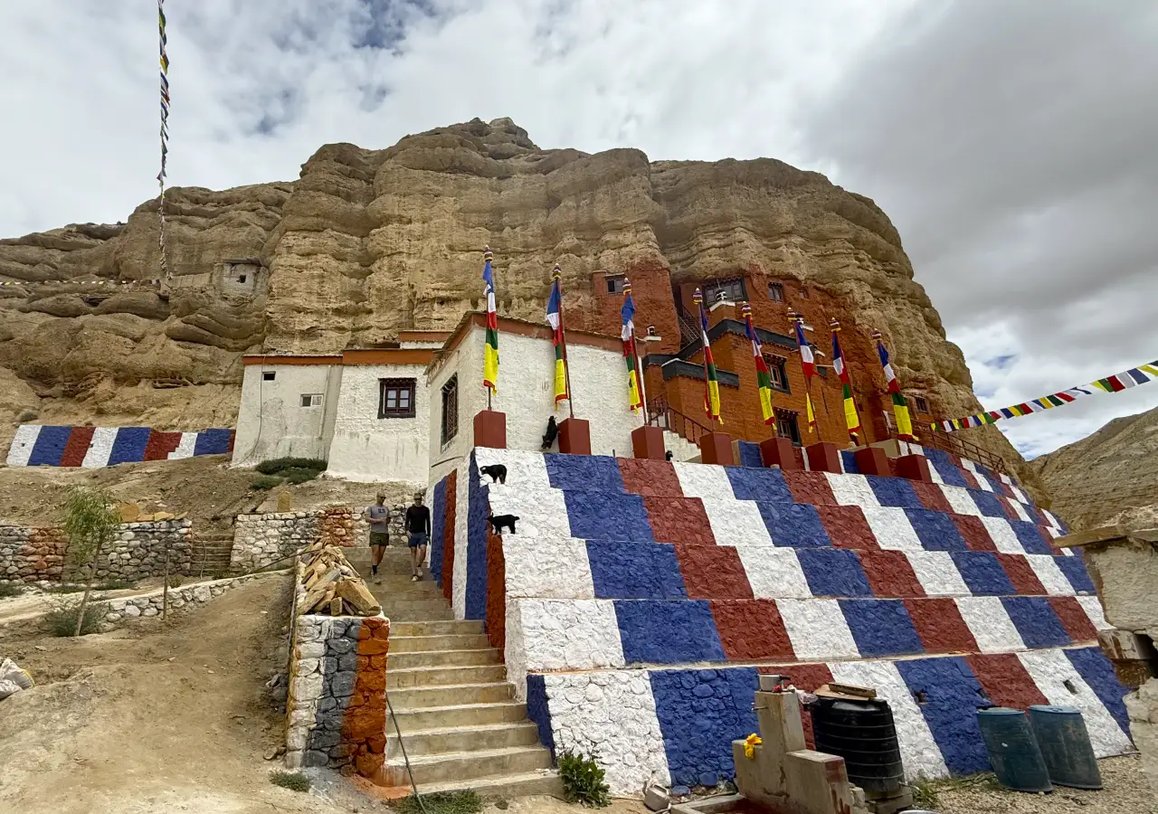 Historical Chhoser cave and colorful prayer flags in the Upper Mustang region of Nepal