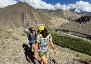 Trekkers hiking through the dramatic landscape of Upper Mustang Nepal on Upper Mustang Trek with Yara Ghara journey