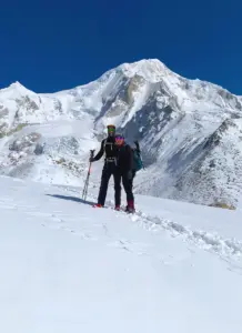 Trekkers hiking in the Manaslu region with clear mountain views, near Larkya La Pass, Nepal